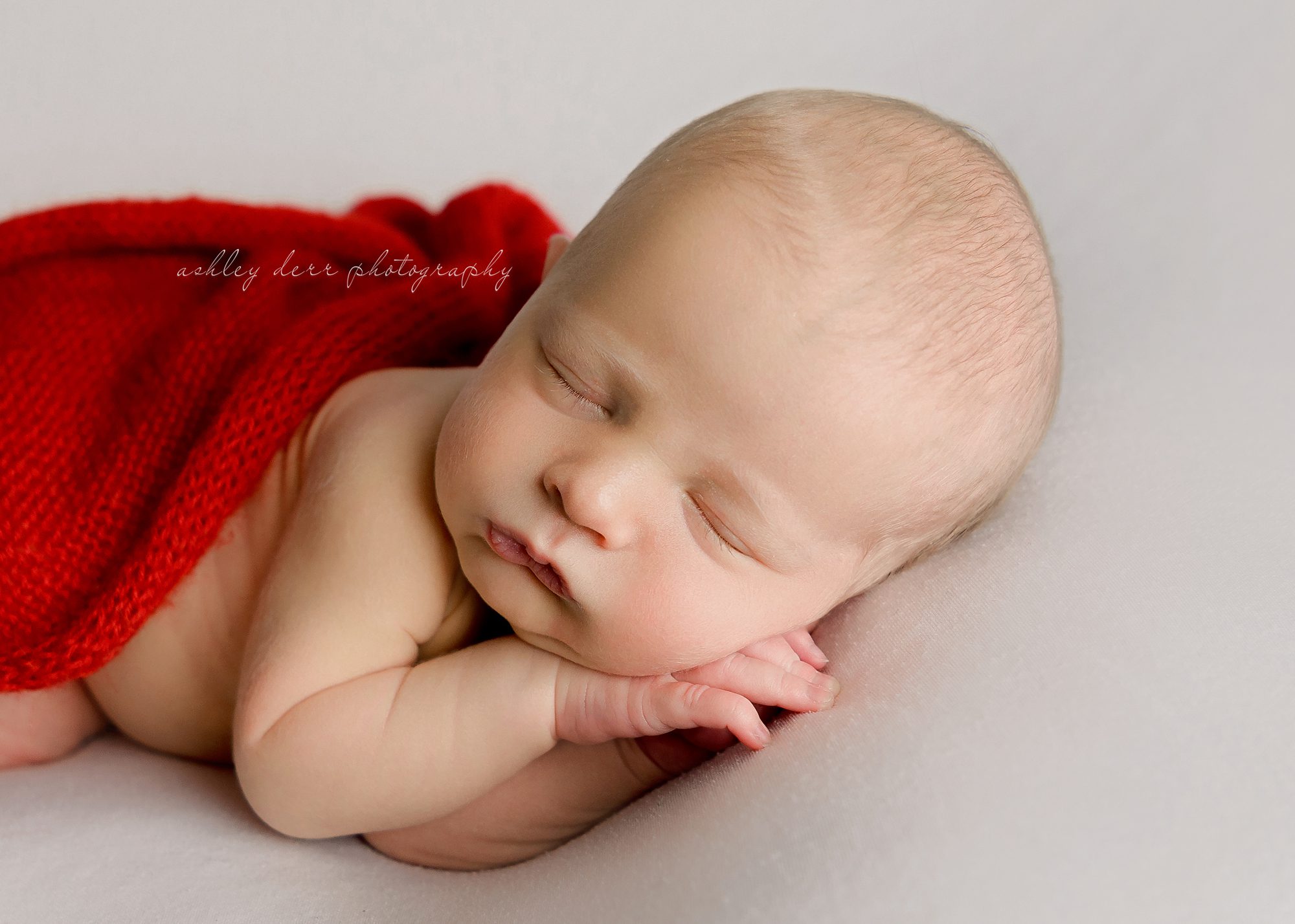 A beautiful wide away baby boy in his Christmas color session